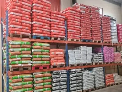 Sacas de alimento para gado empilhadas num armazém